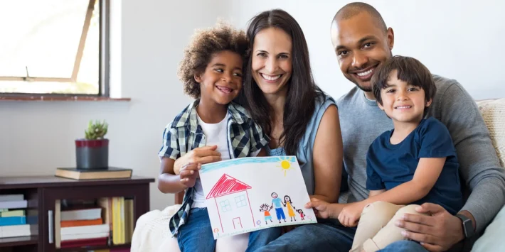 happy family on couch with drawing of family